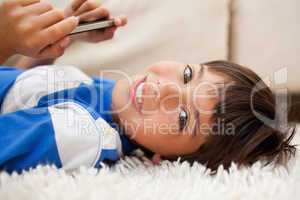 Boy lying on the carpet with cellphone