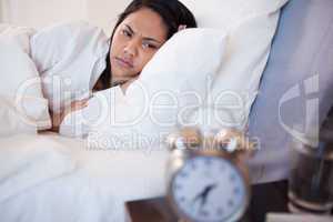 Side view of woman being woken by alarm clock