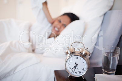 Alarm clock making woman cover her ears