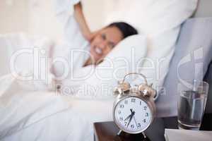 Alarm clock making woman cover her ears