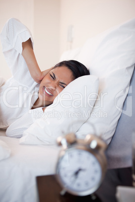 Side view of woman getting ungently woken by alarm clock