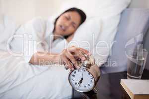 Alarm clock almost falling off the bedside locker while being tu