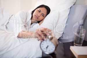 Woman annoyed by ringing alarm clock