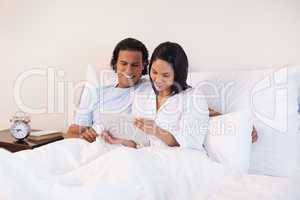 Couple surfing the internet on the bed