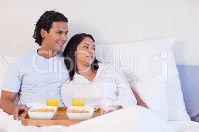 Couple having breakfast in the bed