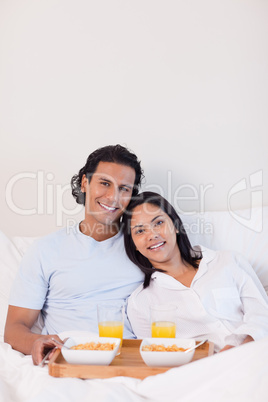 Happy couple having breakfast in the bed