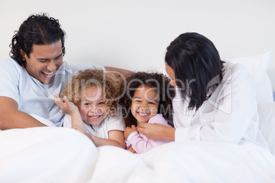 Smiling family sitting on the bed