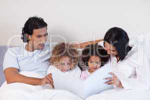 Parents reading a book with their children