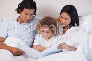 Happy family enjoys reading a book together