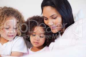 Woman sitting on the bed with her daughters