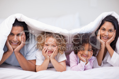 Family hiding under the bed cover