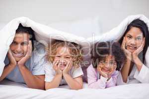 Family hiding under the bed cover