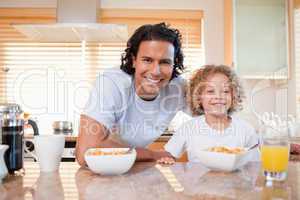 Father and daughter having cereals in the kitchen together