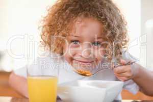 Smiling girl having breakfast
