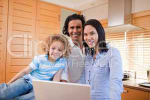 Cheerful family surfing the internet in the kitchen together