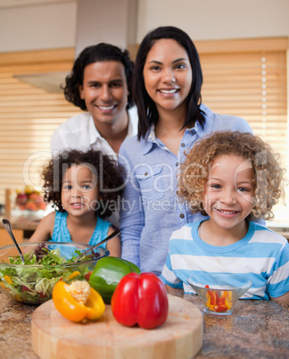 Family with salad together in the kitchen