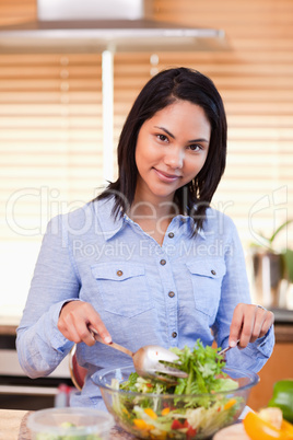 Woman stirring salad in the kitchen