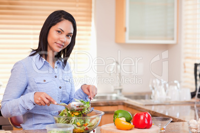 Woman stirring her salad in the kitchen