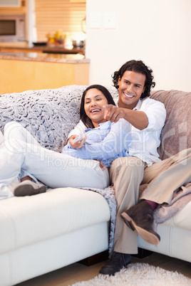 Cheerful couple watching television together