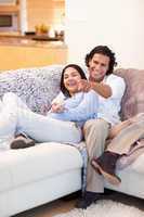 Cheerful couple watching television together