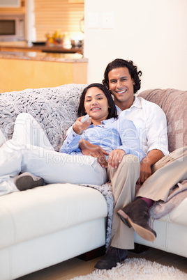 Happy couple watching television together