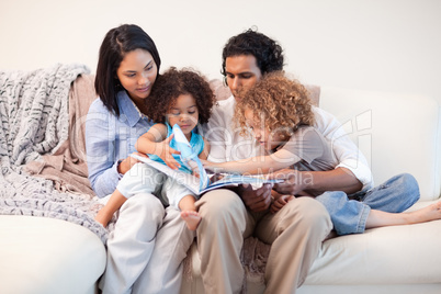 Family on the sofa looking at photo album together