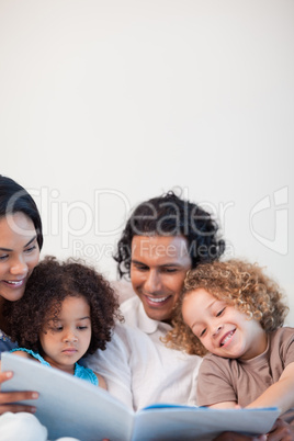 Cheerful family on the sofa looking at photo album together