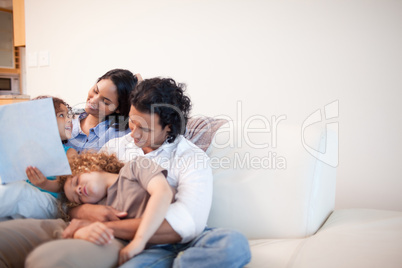 Family in the living room looking at photo album together