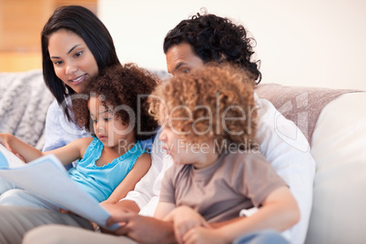 Happy family on the sofa looking at photo album together