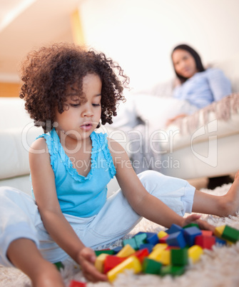 Girl in the living room playing with toy blocks