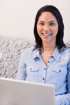 Happy woman on the sofa surfing the internet