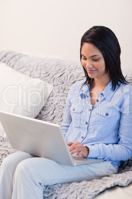 Smiling woman on the sofa with her notebook