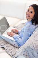 Woman with her laptop sitting on the sofa