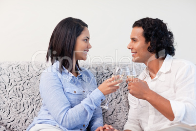 Couple having sparkling wine on the couch