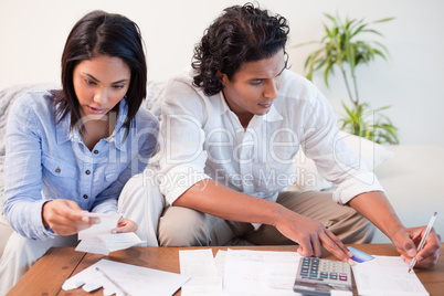 Couple checking bills in the living room