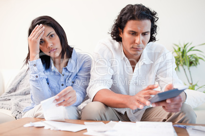 Frustrated couple doing their calculations in the living room