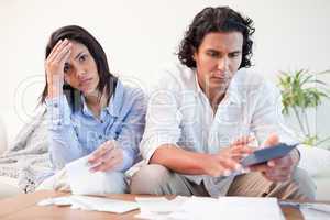 Frustrated couple doing their calculations in the living room