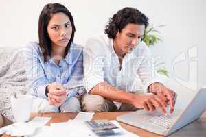 Couple checking their bank accounts online in the living room