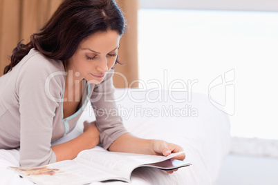 Woman reading magazine on the bed