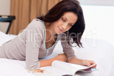 Woman reading a magazine on the bed