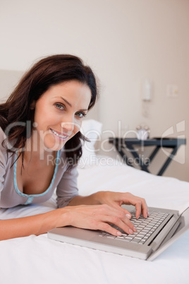 Smiling woman with notebook on the bed