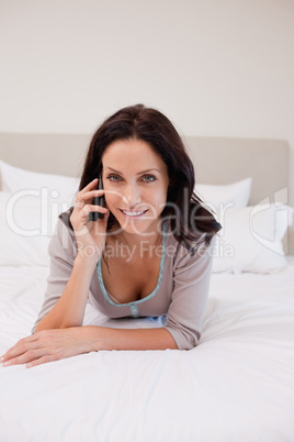 Woman laying on her bed with her mobile phone