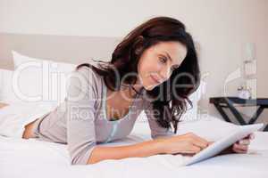 Woman with tablet on her bed