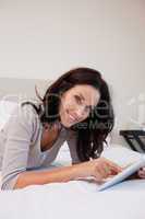 Smiling woman with tablet in the bedroom