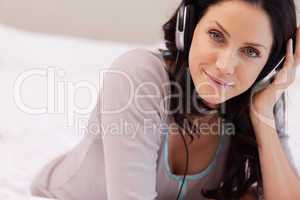 Woman listening to music on her bed