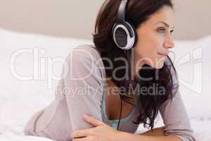 Woman with headphones on her bed
