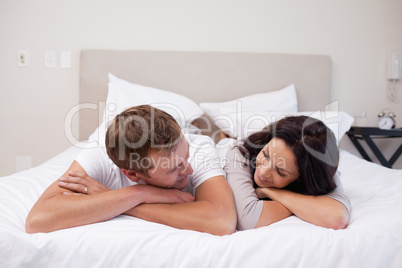 Couple laying on the bed looking at each other