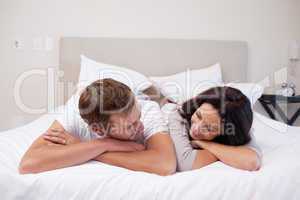 Couple laying on the bed looking at each other