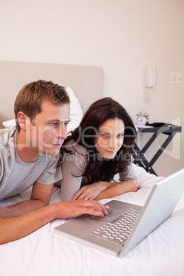 Couple using laptop in the bedroom together