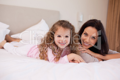 Mother and daughter relaxing in the bedroom together